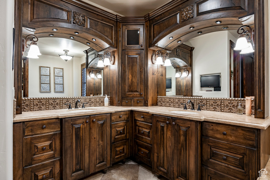 Full bathroom with a sink, decorative backsplash, and double vanity
