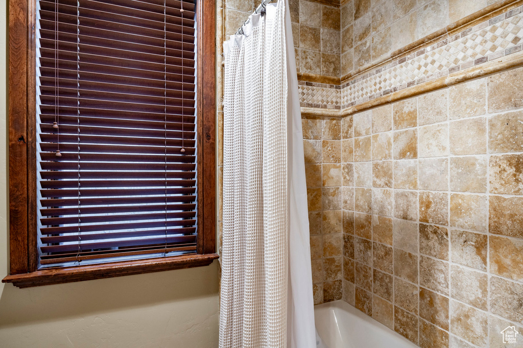 Bathroom with shower / bath combination with curtain