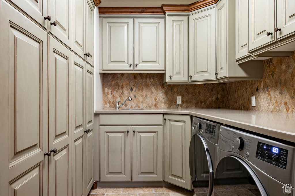 Washroom featuring cabinet space and washing machine and dryer