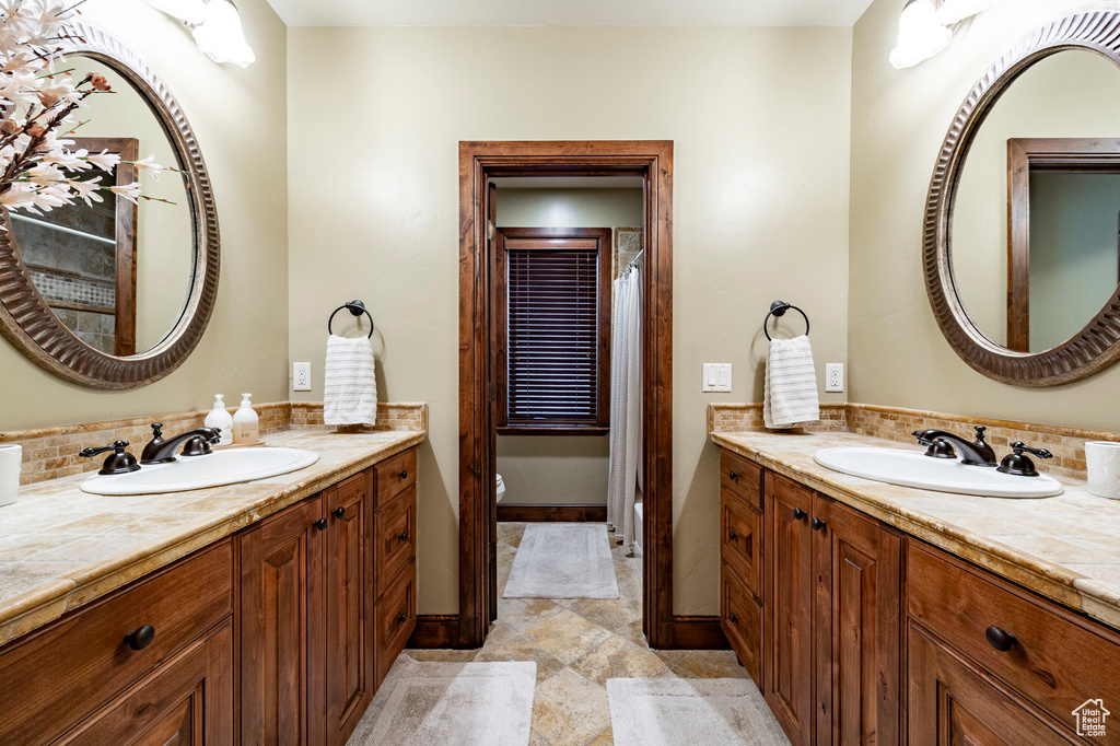 Full bathroom with vanity, baseboards, and toilet