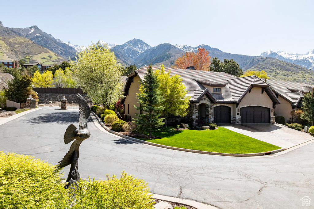 View of front of home featuring a tile roof, a mountain view, stone siding, and stucco siding