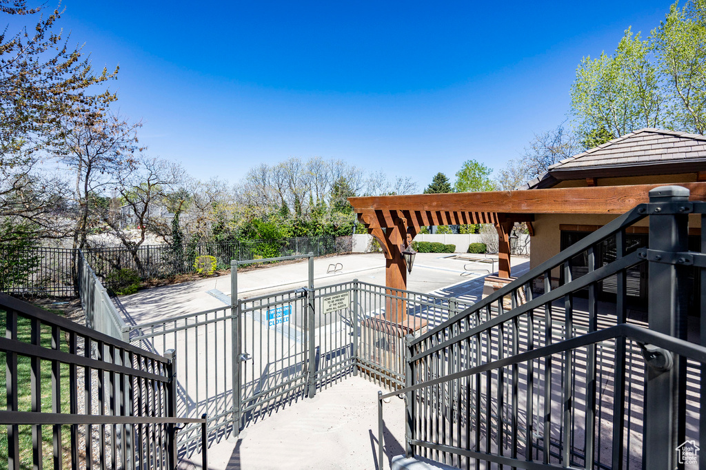 Wooden terrace featuring fence, a fenced in pool, a patio, and stairway