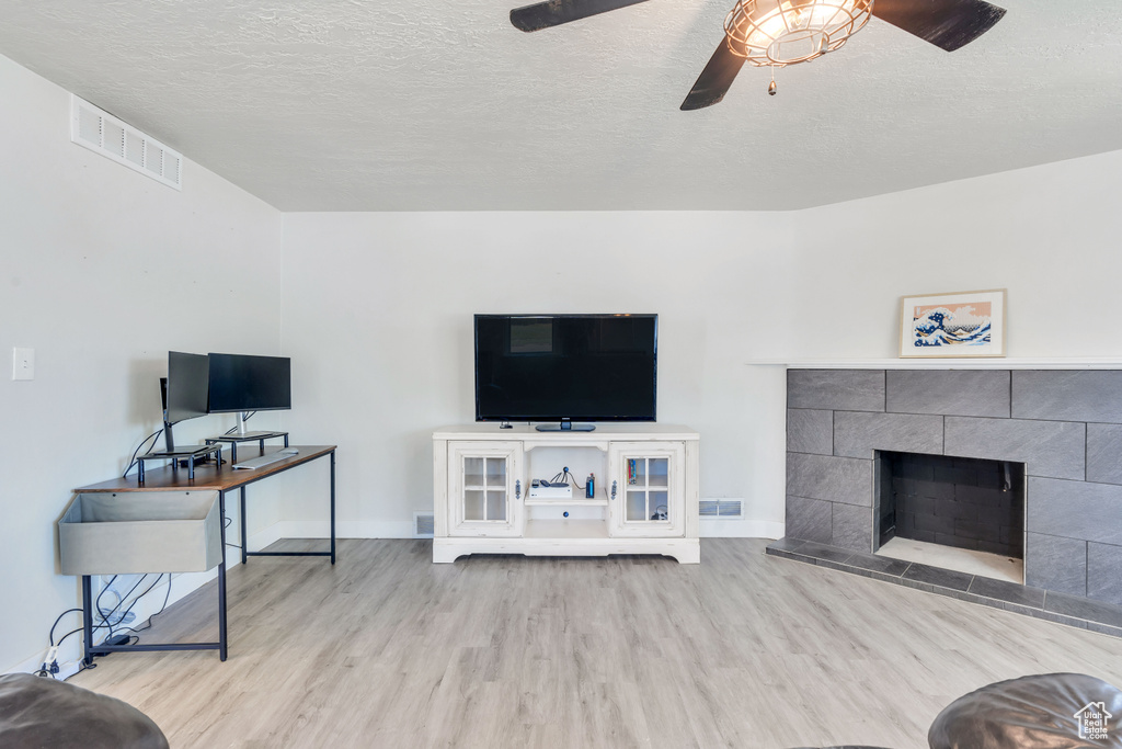 Living room with visible vents, baseboards, ceiling fan, and wood finished floors