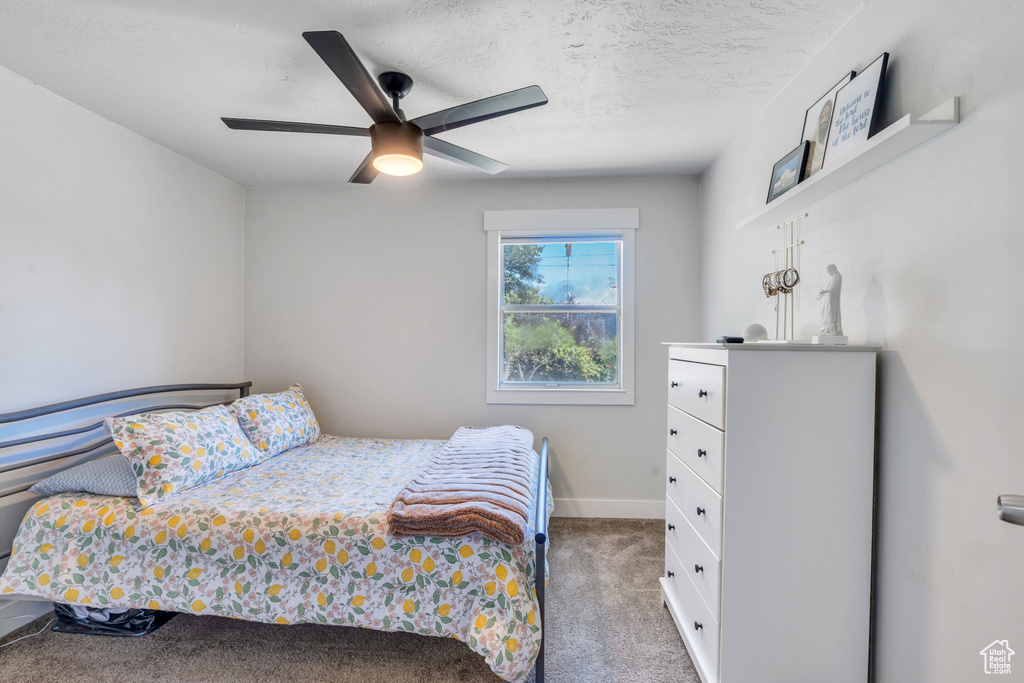 Carpeted bedroom featuring baseboards and a ceiling fan