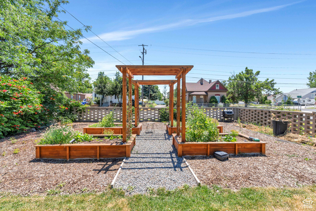 View of play area featuring fence and a vegetable garden