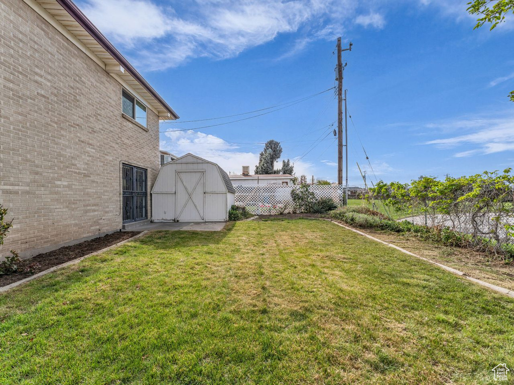 View of yard with an outbuilding, fence, and a storage shed