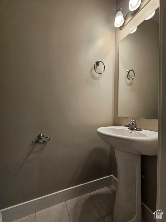 Bathroom with a sink, tile patterned floors, and baseboards