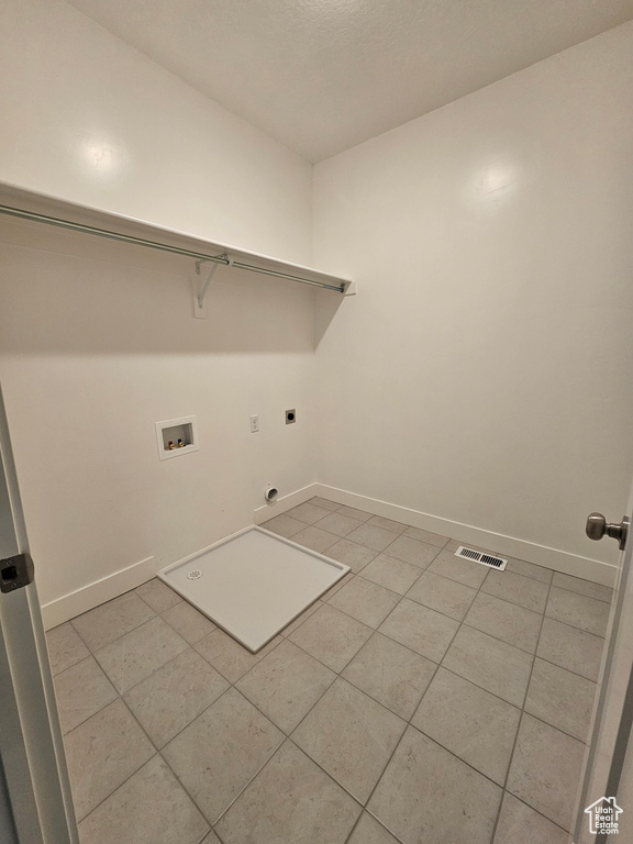 Laundry area featuring hookup for an electric dryer, light tile patterned floors, laundry area, and washer hookup