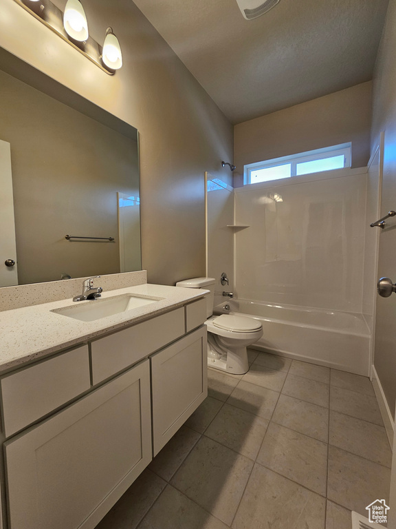Bathroom with toilet, washtub / shower combination, tile patterned flooring, and vanity