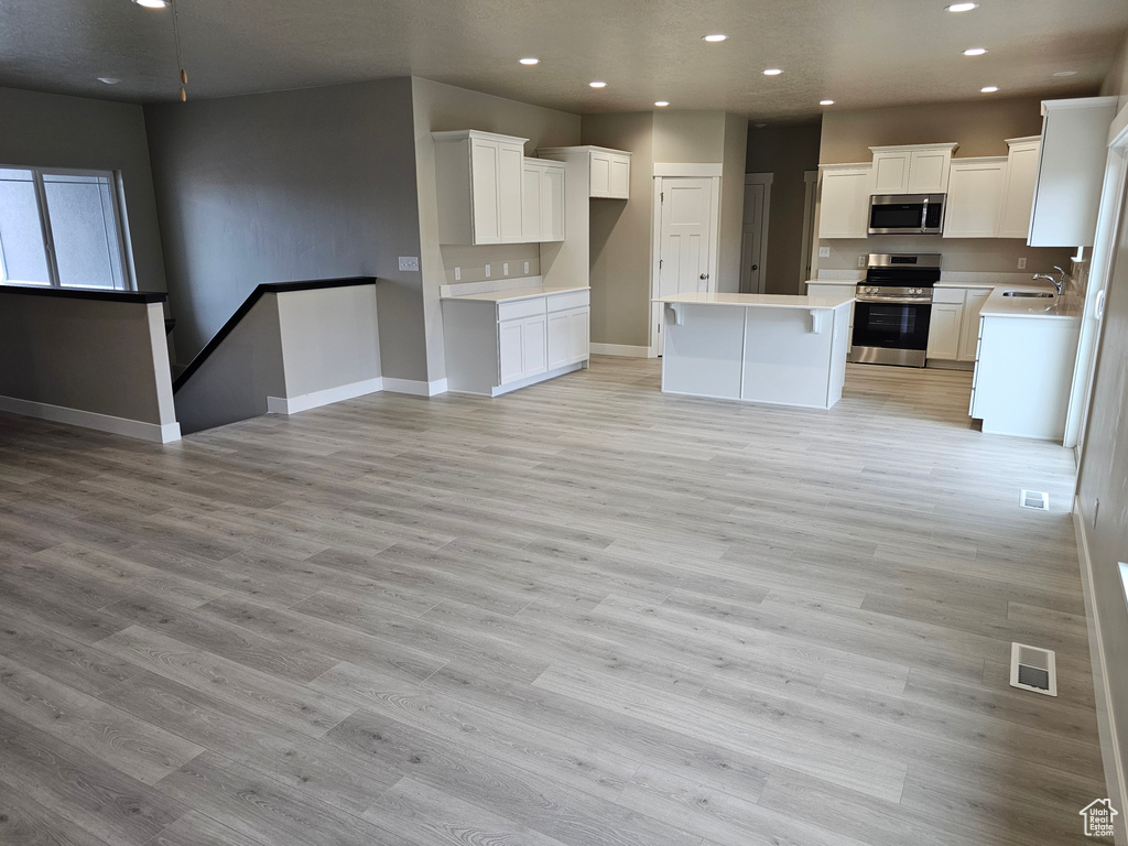 Kitchen featuring a sink, appliances with stainless steel finishes, recessed lighting, and open floor plan