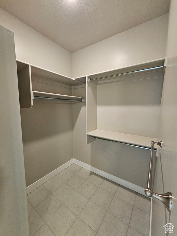 Spacious closet with light tile patterned floors