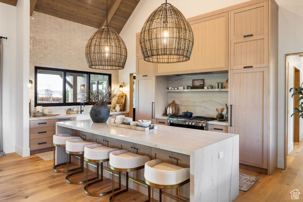 Kitchen featuring light wood-style floors, stove, backsplash, and wooden ceiling