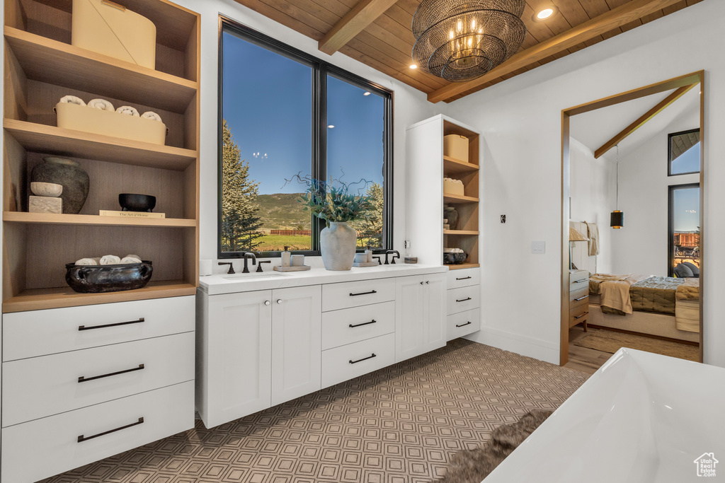 Interior space with a sink and vaulted ceiling with beams