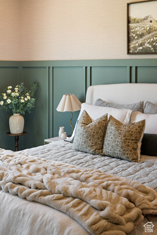 Bedroom featuring a decorative wall
