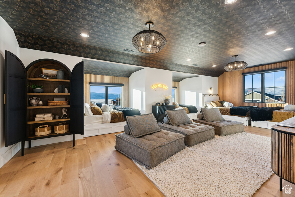 Home theater featuring light wood-style floors, visible vents, and an inviting chandelier