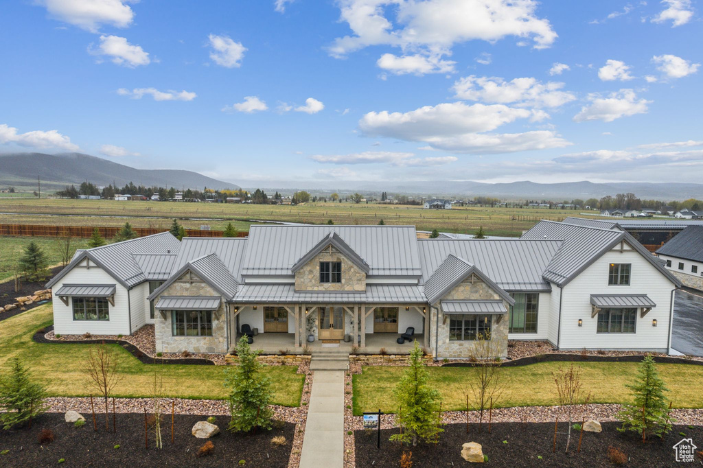 View of front of home with a standing seam roof, a mountain view, and stone siding