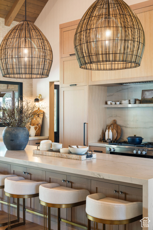 Bar featuring pendant lighting, stove, and beam ceiling