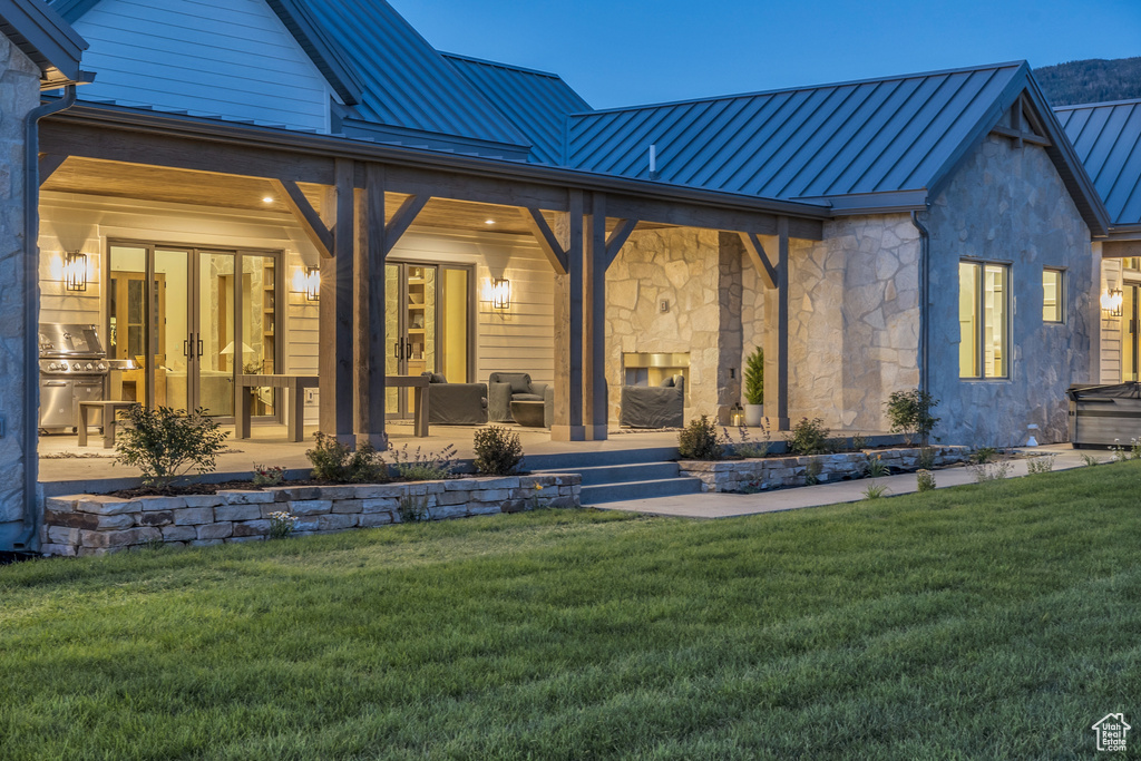 Rear view of property with metal roof, a yard, and a standing seam roof