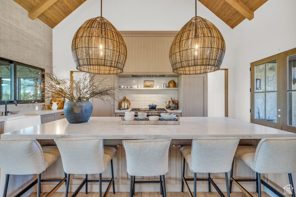 Kitchen featuring wood ceiling, beam ceiling, hanging light fixtures, and high vaulted ceiling