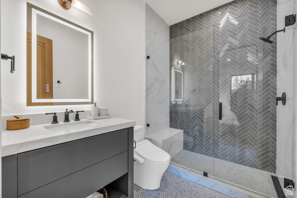 Full bathroom featuring vanity, a stall shower, and toilet