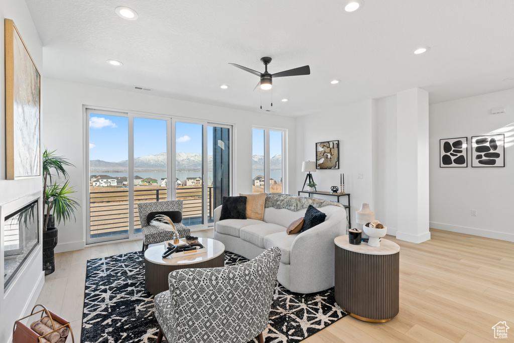Living room featuring recessed lighting, a ceiling fan, light wood-style flooring, and baseboards