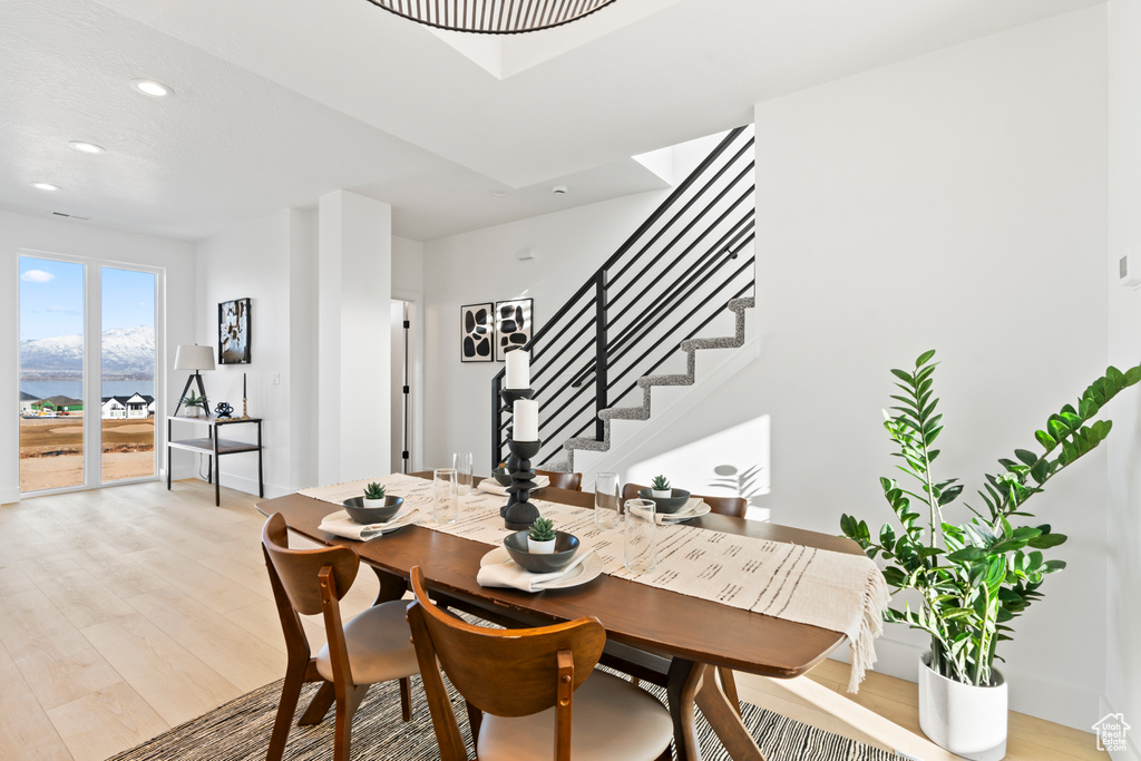 Dining space featuring recessed lighting, baseboards, stairs, and light wood-style flooring