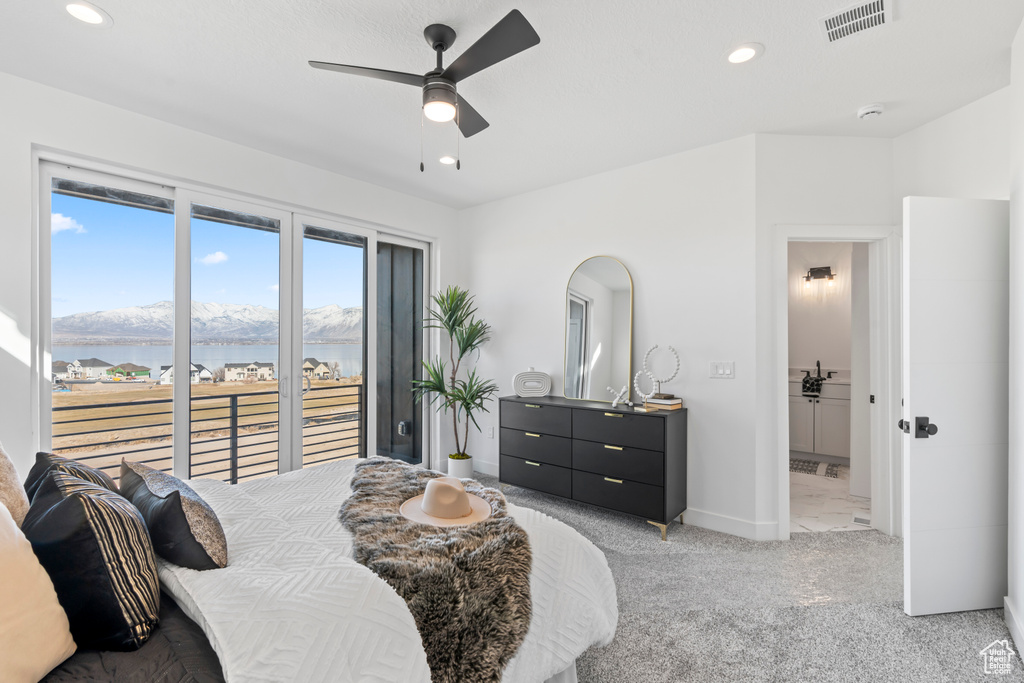 Bedroom featuring a water and mountain view, recessed lighting, visible vents, and light carpet