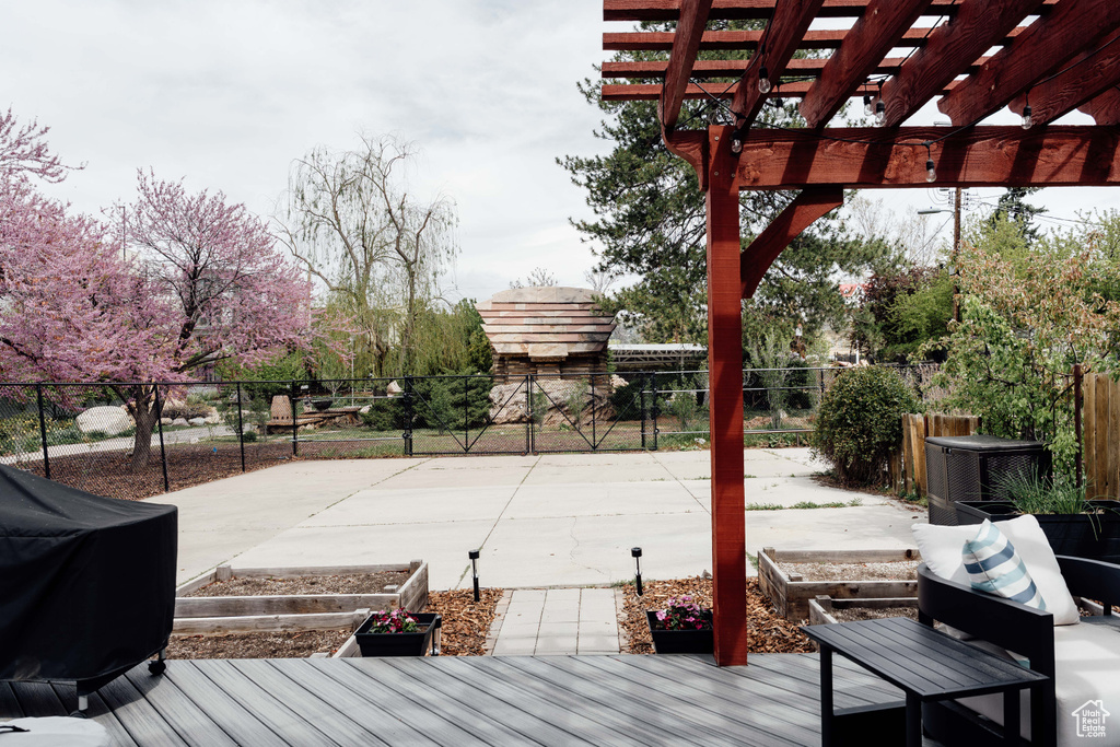 Wooden terrace featuring a fenced backyard and a pergola