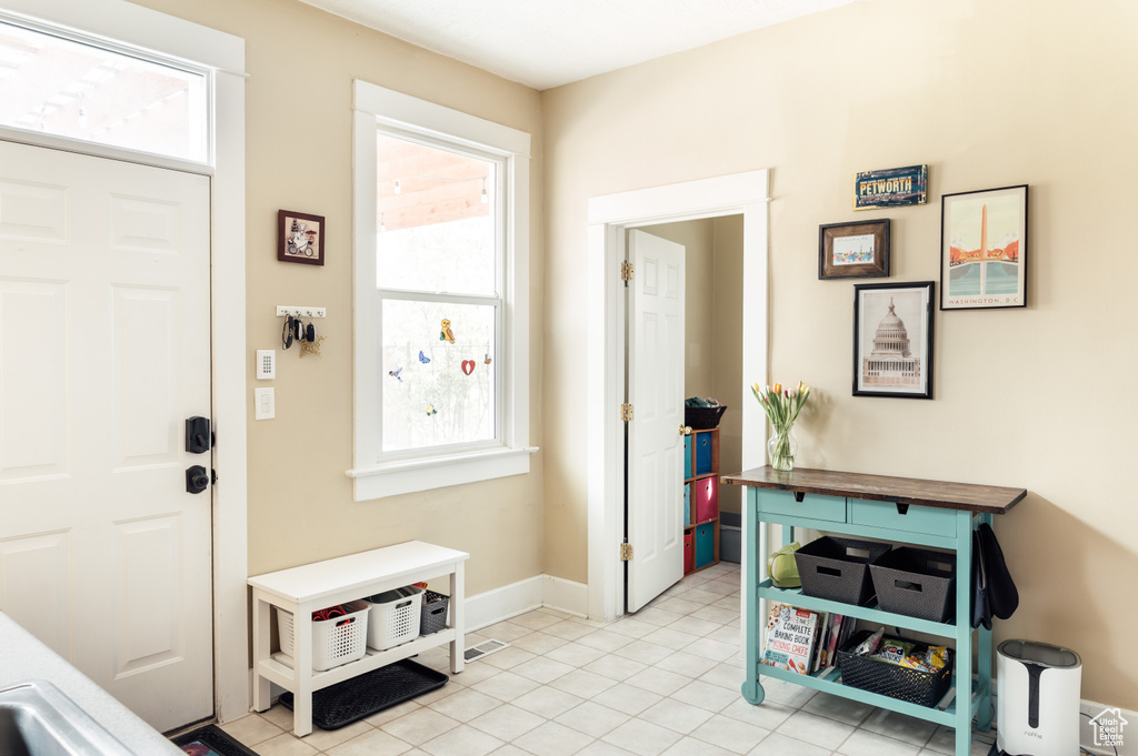 Foyer with baseboards and light tile patterned floors