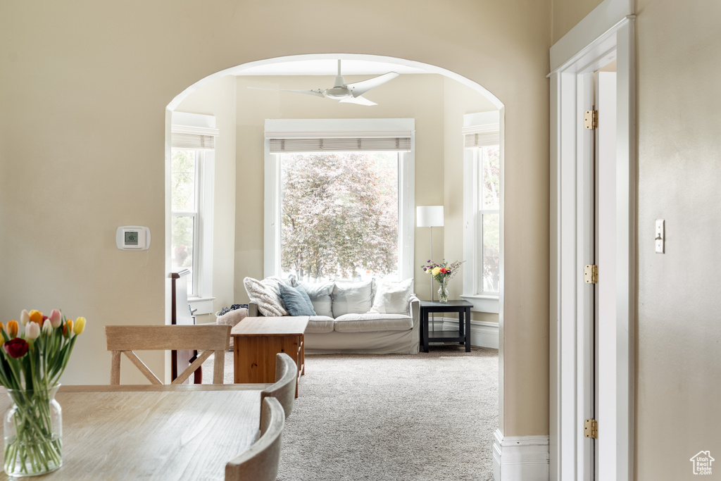 Interior space featuring arched walkways, ceiling fan, and carpet flooring