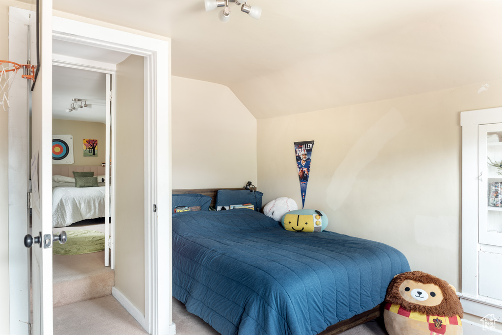 Bedroom featuring carpet flooring and lofted ceiling