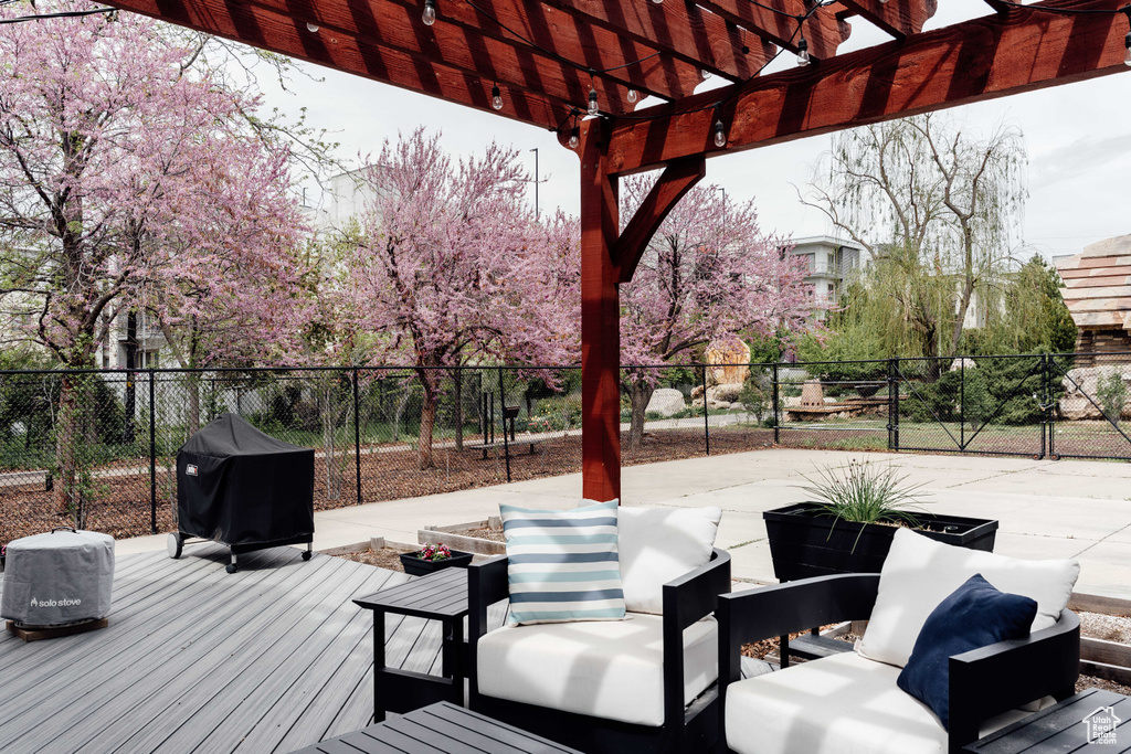 Wooden terrace with outdoor lounge area, fence, a pergola, and area for grilling