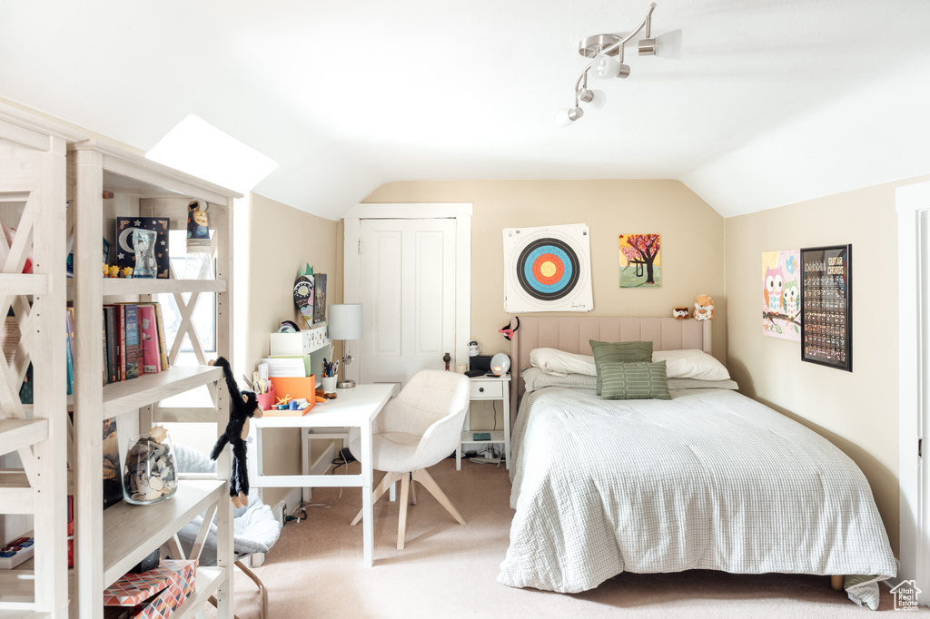Bedroom featuring carpet floors and vaulted ceiling