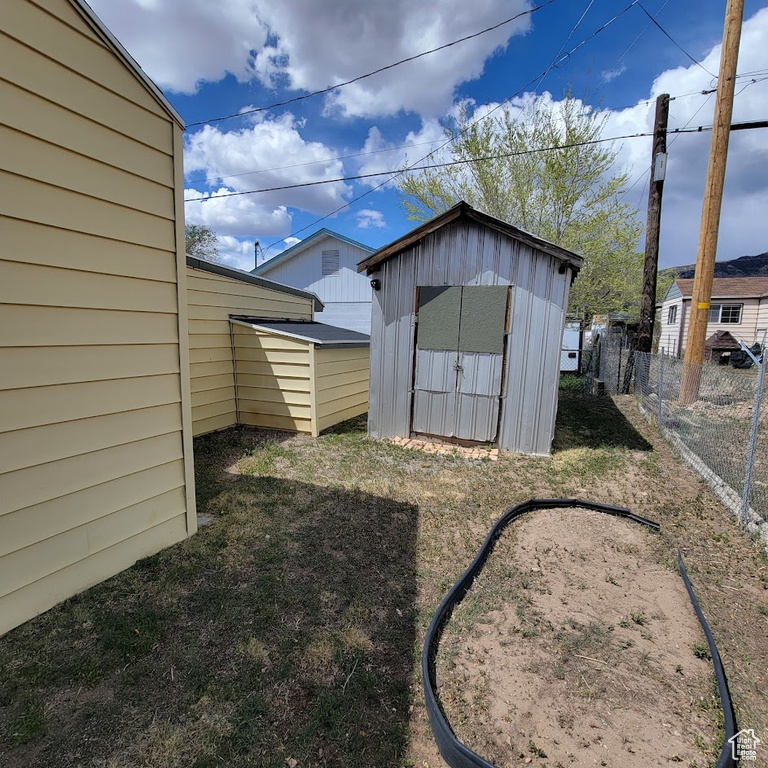 View of shed featuring fence