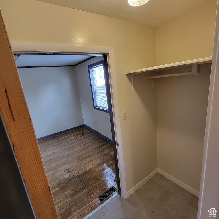 Interior space with baseboards, visible vents, and wood finished floors