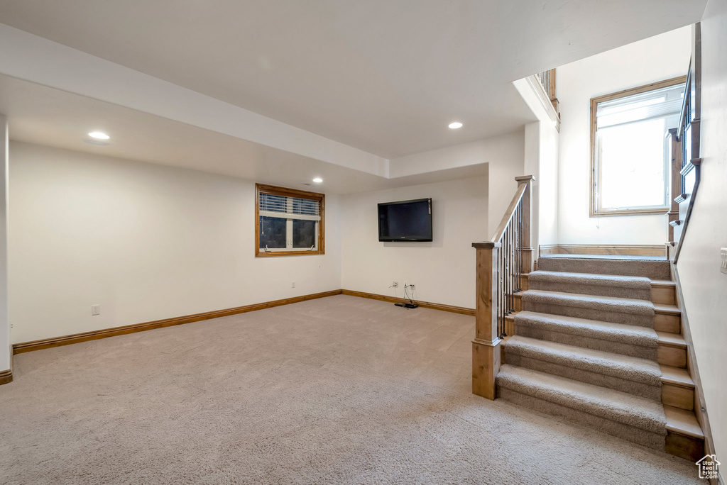 Interior space featuring stairway, baseboards, recessed lighting, and light colored carpet