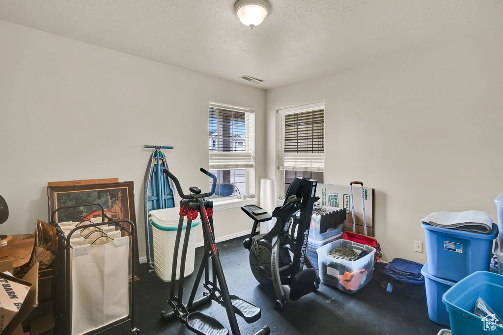 Workout area featuring baseboards and a textured ceiling