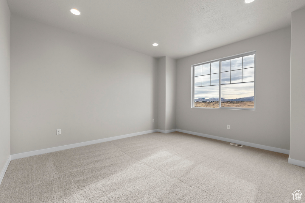 Empty room featuring recessed lighting and light carpet