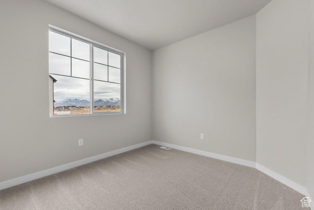 Empty room with baseboards and light colored carpet