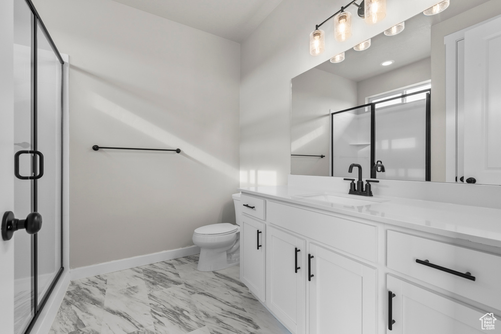 Full bathroom with vanity, a shower stall, toilet, and marble finish floor