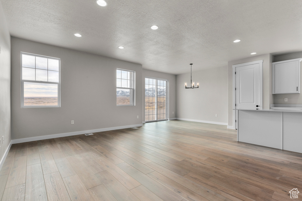 Interior space with an inviting chandelier, recessed lighting, and a textured ceiling