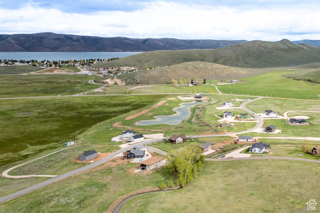Aerial view of property and surrounding area featuring a water and mountain view