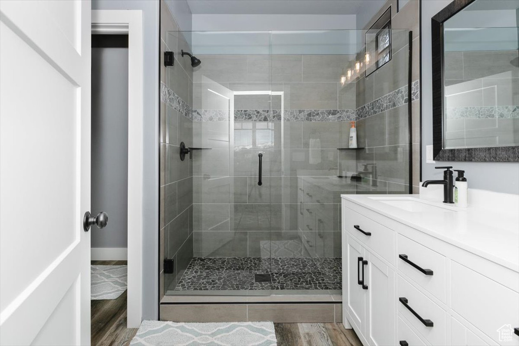 Bathroom with vanity, a stall shower, and wood finished floors