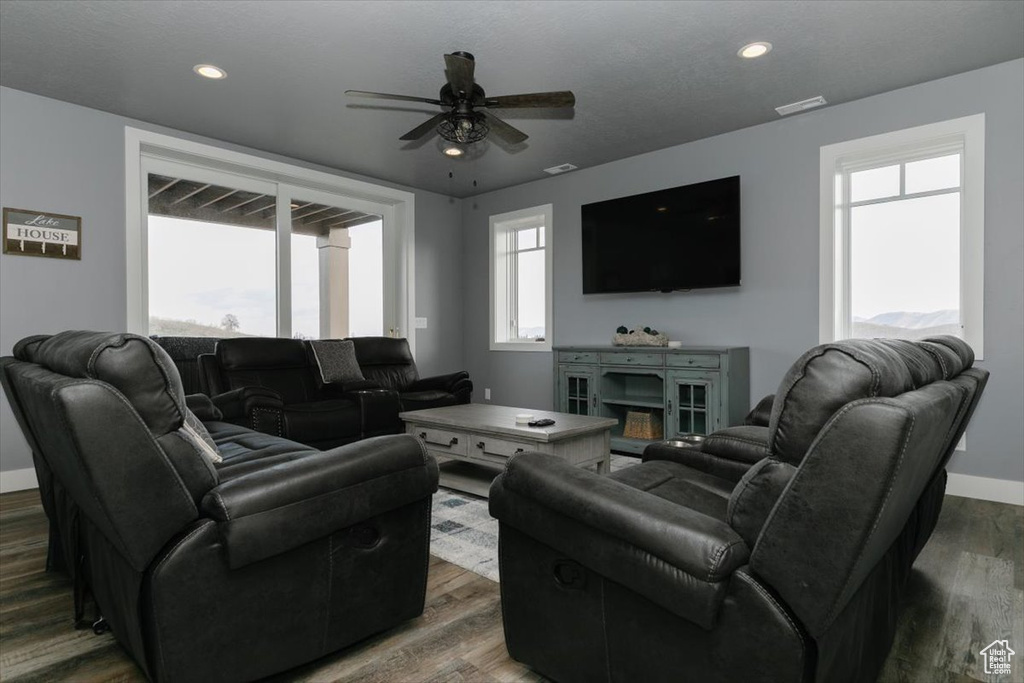 Living room with visible vents, baseboards, a ceiling fan, and wood finished floors