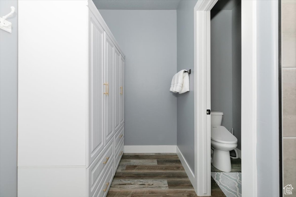 Bathroom with baseboards, toilet, and wood finished floors