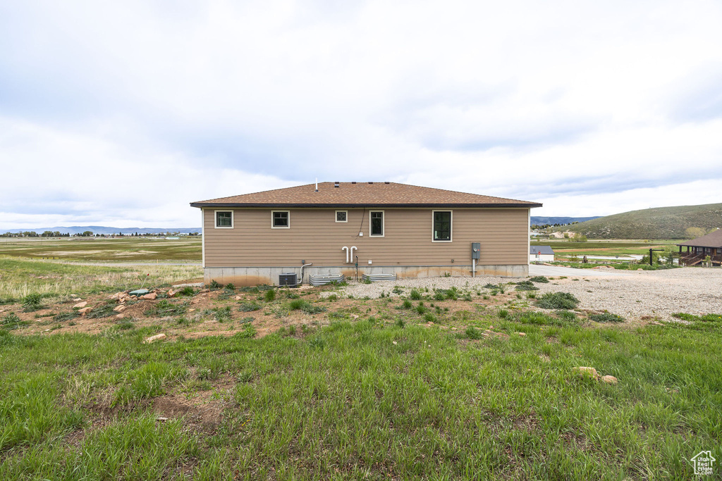 Rear view of house with central AC and a view of rural / pastoral area