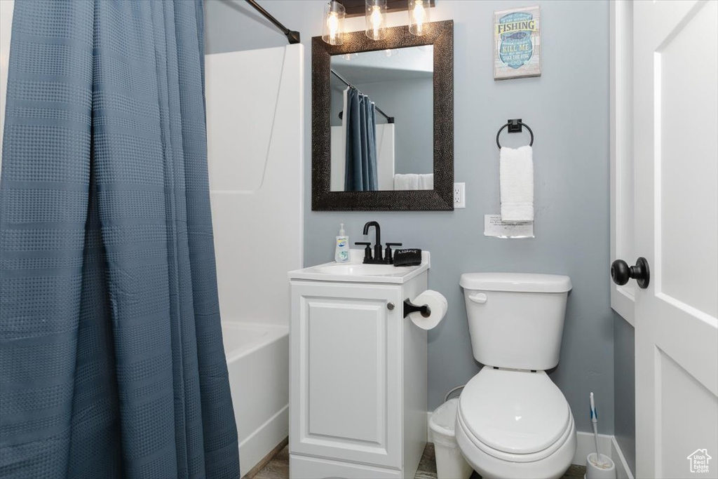 Bathroom featuring shower / bath combo, toilet, and vanity