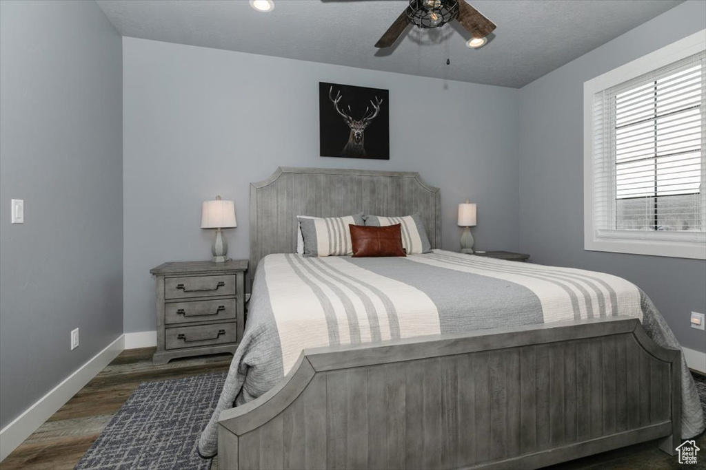 Bedroom with wood finished floors, baseboards, and a ceiling fan