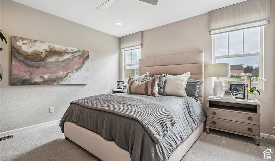 Bedroom with baseboards, carpet, a ceiling fan, and visible vents