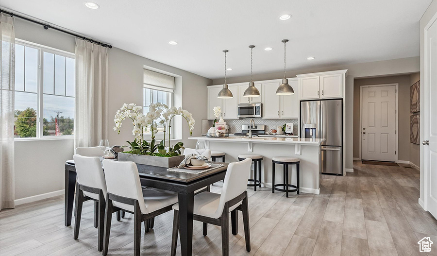 Dining space featuring baseboards, recessed lighting, and light wood-type flooring